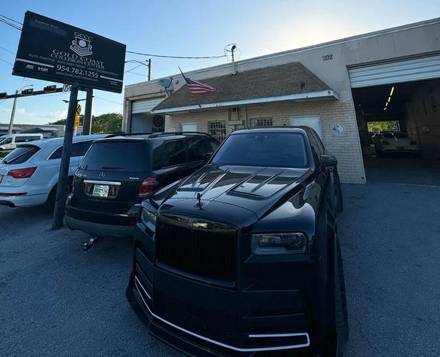 Gold Coast Collision Center storefront on S Dixie Hwy with a black Rolls-Royce Cullinan parked in front