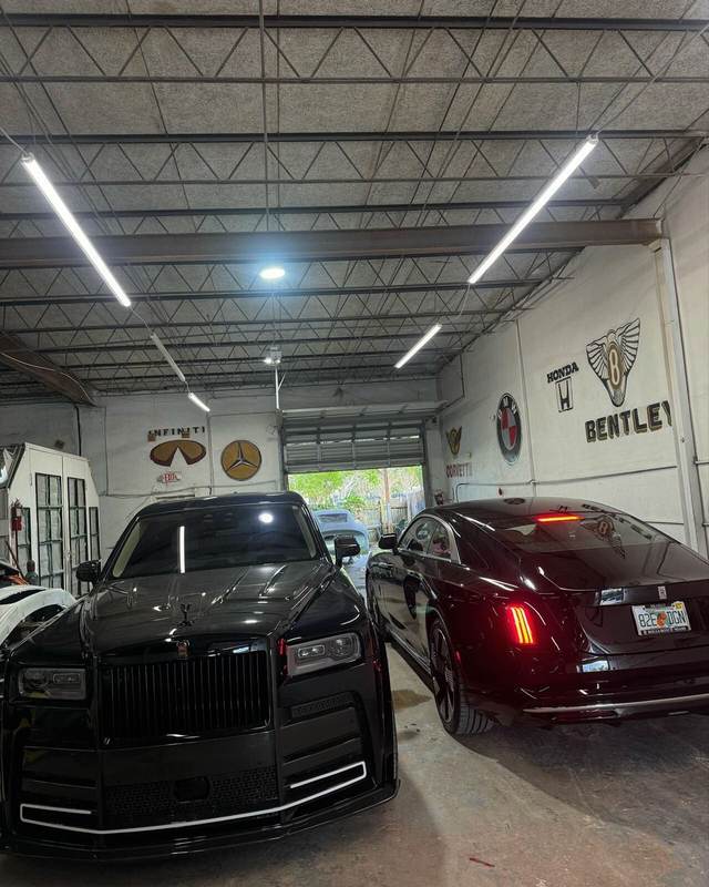 Rolls-Royce Cullinan and Spectre inside the Gold Coast Collision Center shop under LED lighting